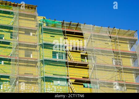 scaffolding arround the house to install thermal insulation of the apartment building facade Stock Photo