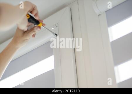 Man installing cassette roller blinds on windows Stock Photo