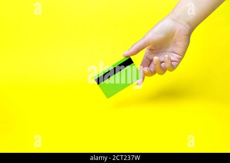 Hand holding business card, mockup, on yellow background Stock Photo