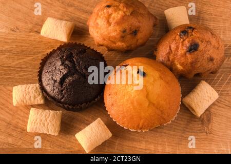Cupcakes and airy crispy corn pads scattered on a wooden board Stock Photo