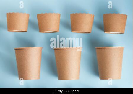 Brown baking cups and coffee cups isolated on light blue background.  Stock Photo