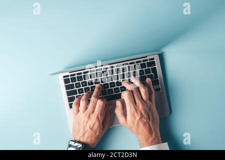 Businessman typing laptop computer keyboard, top view with copy space - male hand working on modern 13 inch notebook portable computer Stock Photo