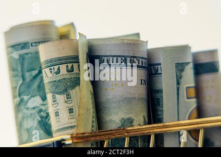Supermarket grocery push cart for shopping with bundle of dollars money banknote cash. Dollars in the cart. Stock Photo