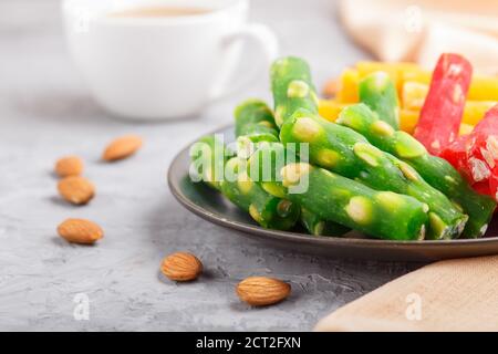 Set of various traditional turkish delight (rahat lokum) in blue ceramic plate with cup of coffee on a gray concrete background. side view, close up, Stock Photo