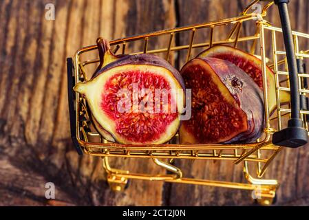Fresh figs . Beautiful blue violet figs. Figs in grocery cart on wood background Stock Photo