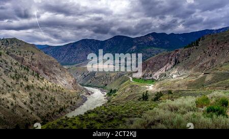 Lightning Strike and a Flock of Birds in Bad weather hanging over the Fraser Canyon and Highway 99 near Lillooet in British Columbia, Canada Stock Photo
