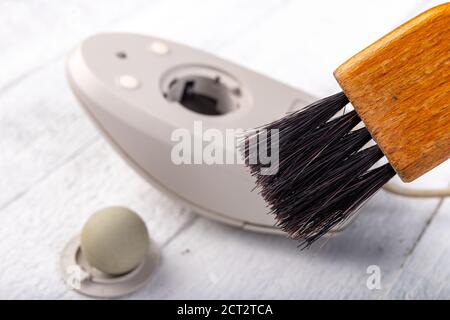 Cleaning with a brush of an old mouse. Office accessories for work. Light background. Stock Photo