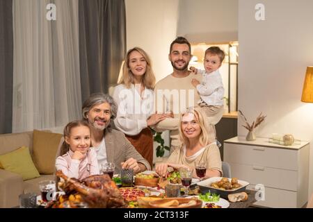 Happy contemporary family of three generations looking at you with smiles Stock Photo