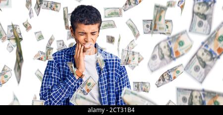 Young african amercian man wearing casual clothes touching mouth with hand with painful expression because of toothache or dental illness on teeth. de Stock Photo