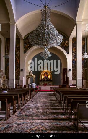 Tehran,Iran,27 August,2020:Hall with benches for parishioners, an altar with an icon of the Virgin, crystal chandeliers, from under the arched ceiling Stock Photo