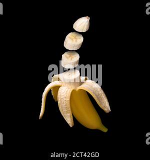 Banana isolated on black background. Surreal design. Pieces of fruit floating in the air Stock Photo