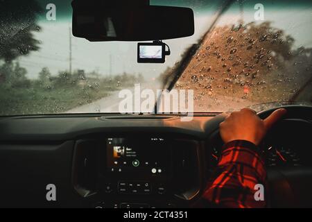 Man driving a car in the rain at night driving bad weather conditions on road