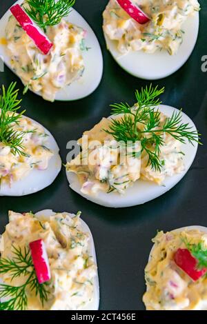 a portrait birds eye view of some freshly made stuffed boiled eggs on a plate Stock Photo