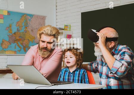 Three generations of active men playing computer games in living room. Happy multi generation family. Fathers Day. Stock Photo