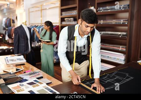 Seamstress measuring tape. working on textile industry fabric close up.  Unrecognizable person Stock Photo - Alamy