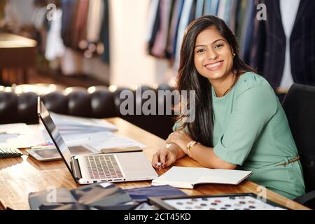 Happy young Indian atelier owner Stock Photo
