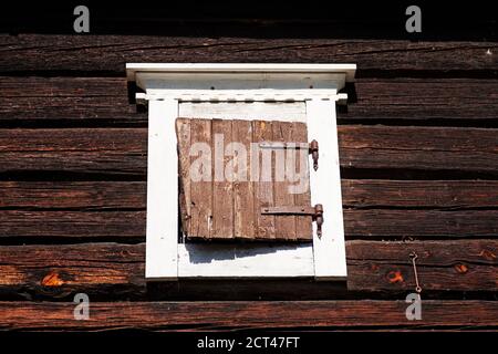 a window covered with a wooden shutter on an old house Stock Photo