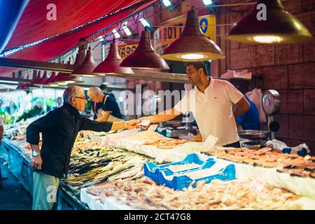 Sicilian person buying seafood at Ortigia Market, Syracuse (Siracusa), Sicily, Italy, Europe Stock Photo