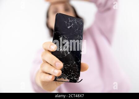 Broken glass screen of phone in hands of woman, white background Stock Photo