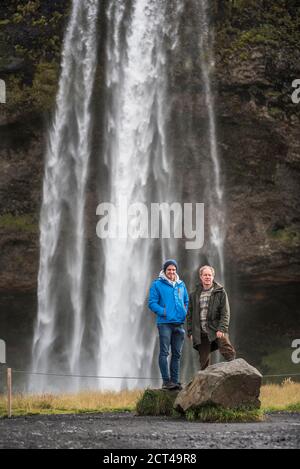 Father and son at Seljalandsfoss, a famous waterfall just off route 1 in South Iceland (Sudurland), Europe Stock Photo