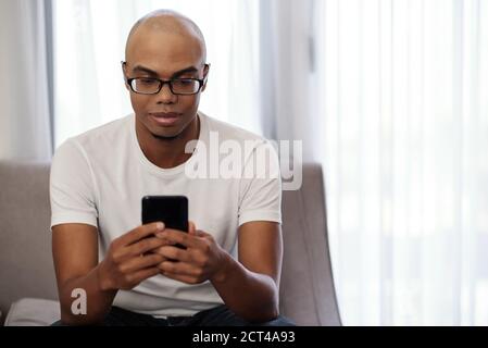 Smiling man checking smartphone Stock Photo
