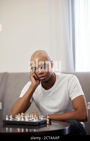 Man looking at chess board Stock Photo