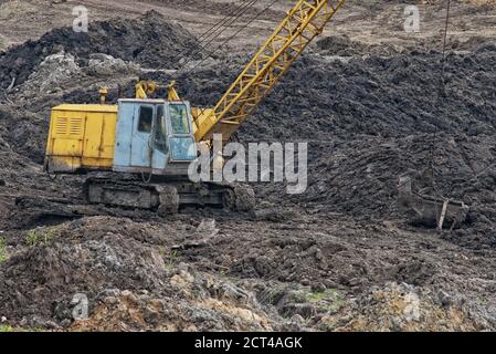 Construction caterpillar excavator crane in muddy soil Stock Photo