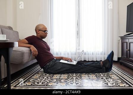 Man reading document on laptop Stock Photo