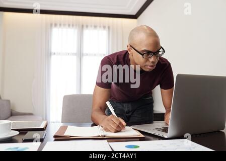 Businessman checking reports on laptop Stock Photo