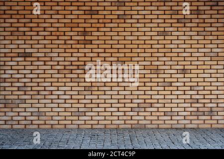 Backdrop of red brick wall and gray pavement Stock Photo