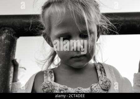 Close up black and white portrait of cute resentful and sad Caucasian child. Children's sincere emotions. Childhood moments. Child in nature.
