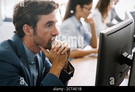 Programmers cooperating at IT company developing apps Stock Photo