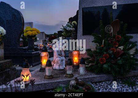 rememberance candle lanterns in the cemetery on all saints day with angel statue Stock Photo