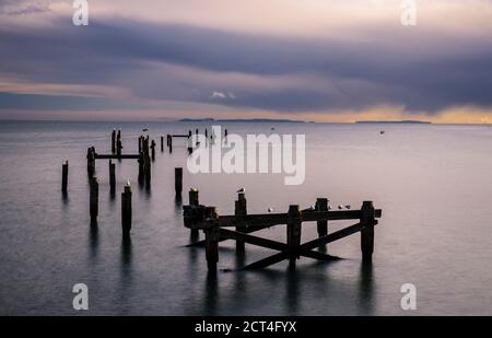 The old pier at Swanage in Dorset south west England with the Isle of Wight on the horizon Stock Photo