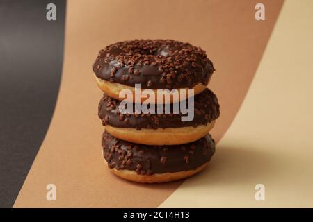 Tasty chocolate donuts on three tone background Stock Photo