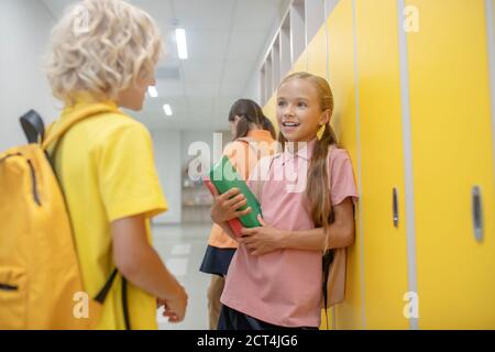 Boy and girl talking in the corridor standing near the lockers Stock Photo