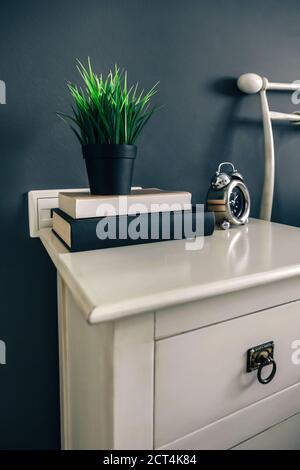 Bedside table with books and plant Stock Photo