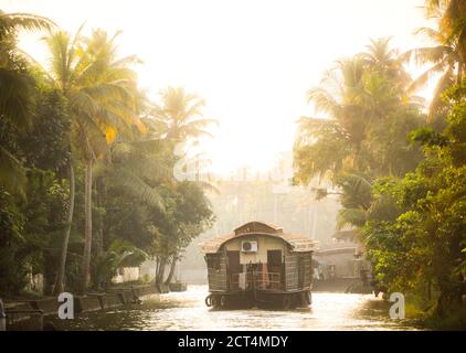 Houseboat tourist boat trip on an excusrion in the Kerala backwaters at sunset near Alleppey, Alappuzha, India Stock Photo