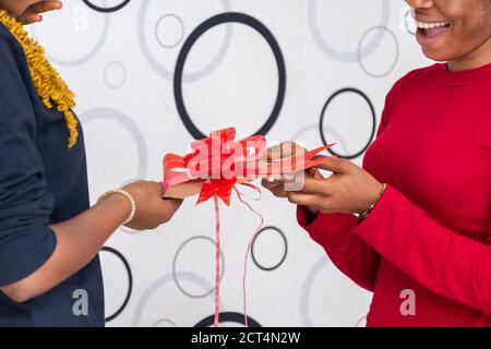 african lady giving a friend a present Stock Photo