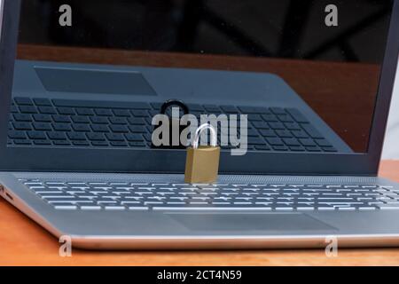 a secure laptop concept, locked padlock placed on a laptop computer Stock Photo