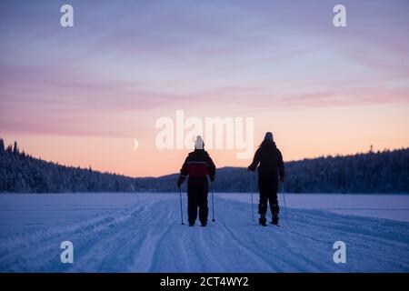 Skiing on the frozen lake at Torassieppi at sunset, Lapland, Finland Stock Photo