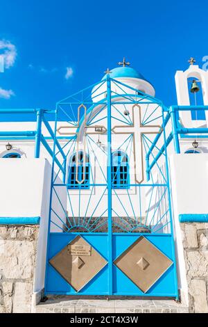 Blue and Gold Chapel Gate, Traditional white Chapel with blue dome and small bell tower right behind it, Karpathos Island, Greece Stock Photo