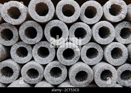 Stacked insulation for pipes of polyethylene foam in warehouse Stock Photo