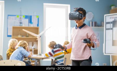 Elementary School Computer Science Class: Cute Girl Wearing Augmented Reality Headset and Using Controllers Learns Lessons in Virtual Reality Excited Stock Photo