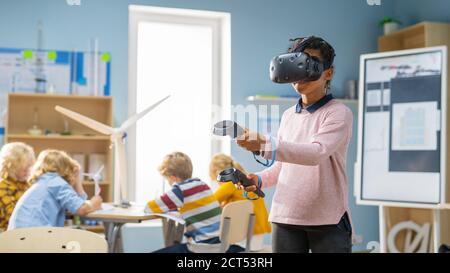 Elementary School Computer Science Class: Cute Girl Wearing Augmented Reality Headset and Using Controllers Learns Lessons in Virtual Reality Excited Stock Photo