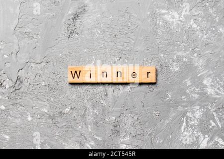 WINNER word written on wood block. WINNER text on cement table for your desing, concept. Stock Photo