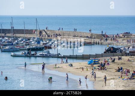Lyme Regis, Dorset, UK. 21st Sep, 2020. UK Weather: A scorching hot start to the week at the seaside resort of Lyme Regis. Visitors and locals make the most of the last of the baking hot September sunshine and bright blue skies before cooler, more seasonal conditions set in with the arrival of Storm Aiden later this week. Credit: Celia McMahon/Alamy Live News Stock Photo