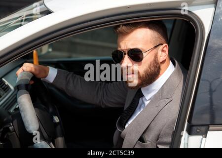 handsome caucasian businessman sits inside of representative luxurious car, confident male in formal wear Stock Photo