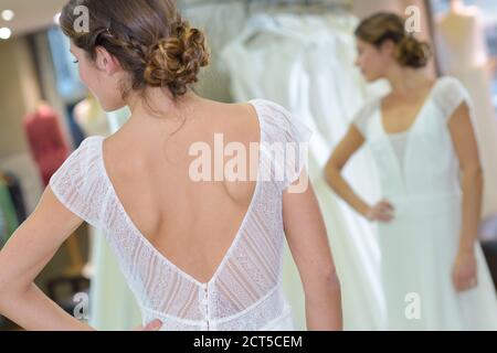 female trying on wedding dress in a shop Stock Photo