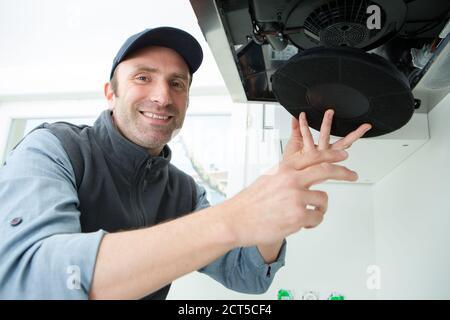 male technician working on kitchen extractor filter Stock Photo